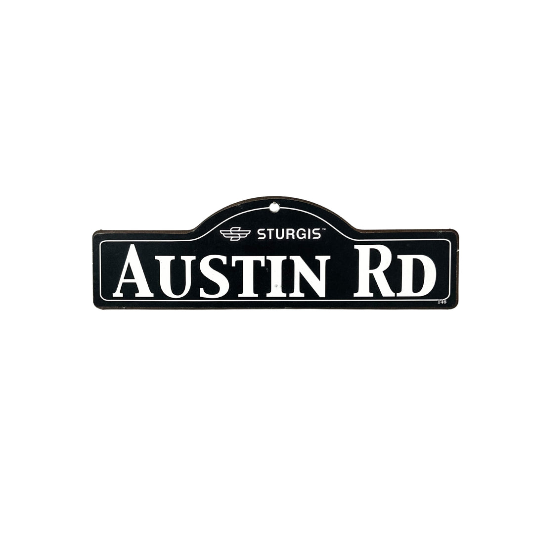 Austin Sturgis wooden street name sign with white lettering on black