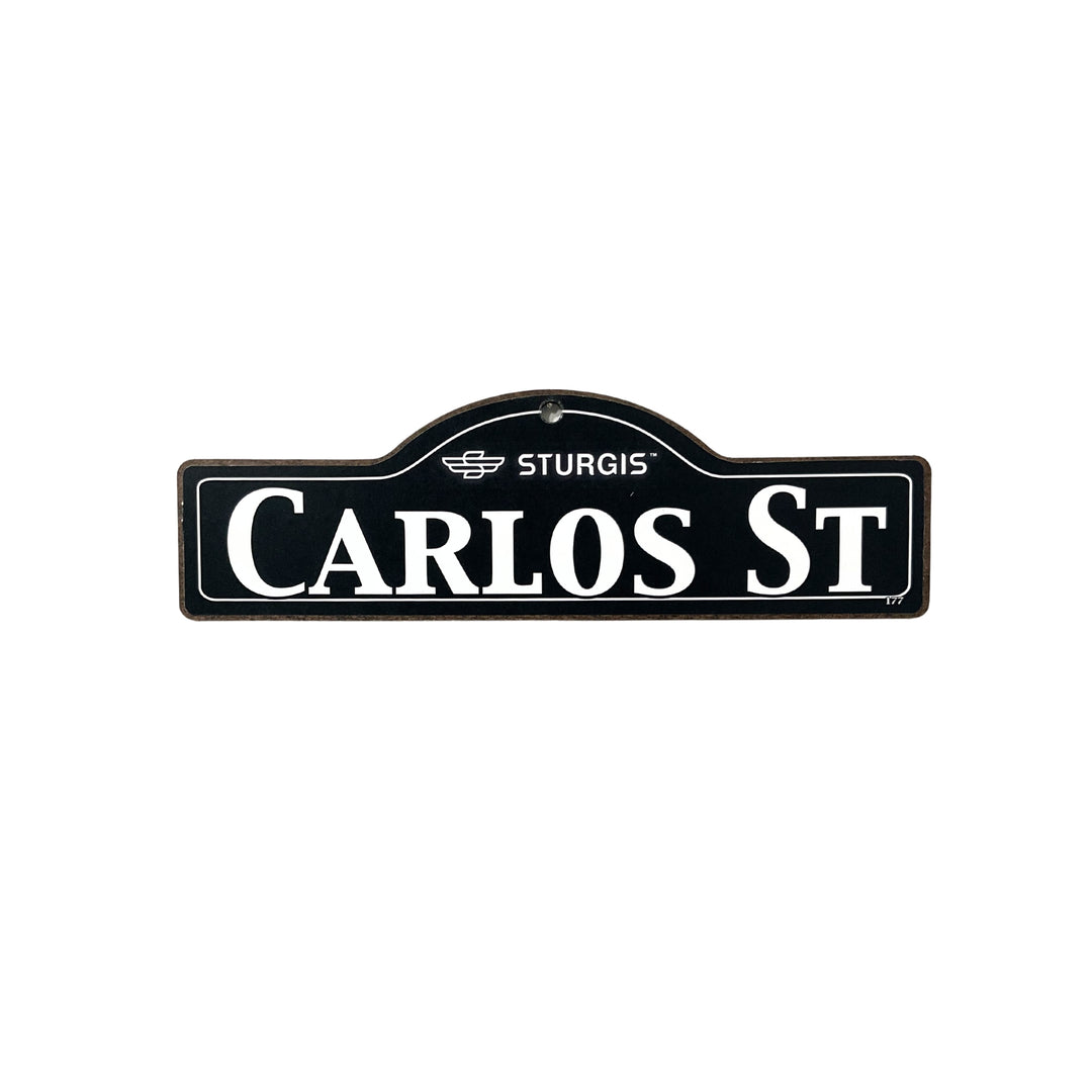 Carlos Sturgis wooden street name sign with white lettering on black