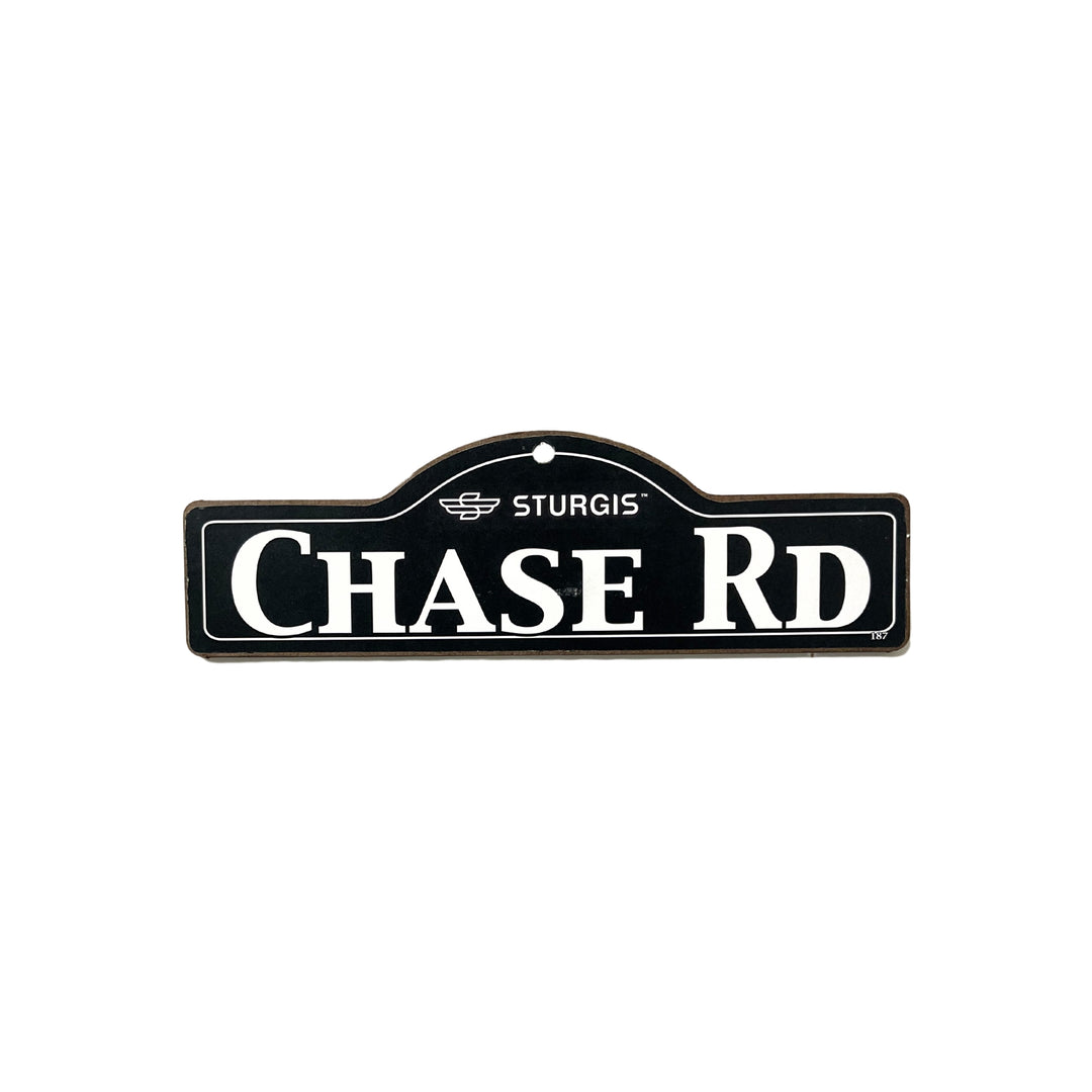 Chase Sturgis wooden street name sign with white lettering on black