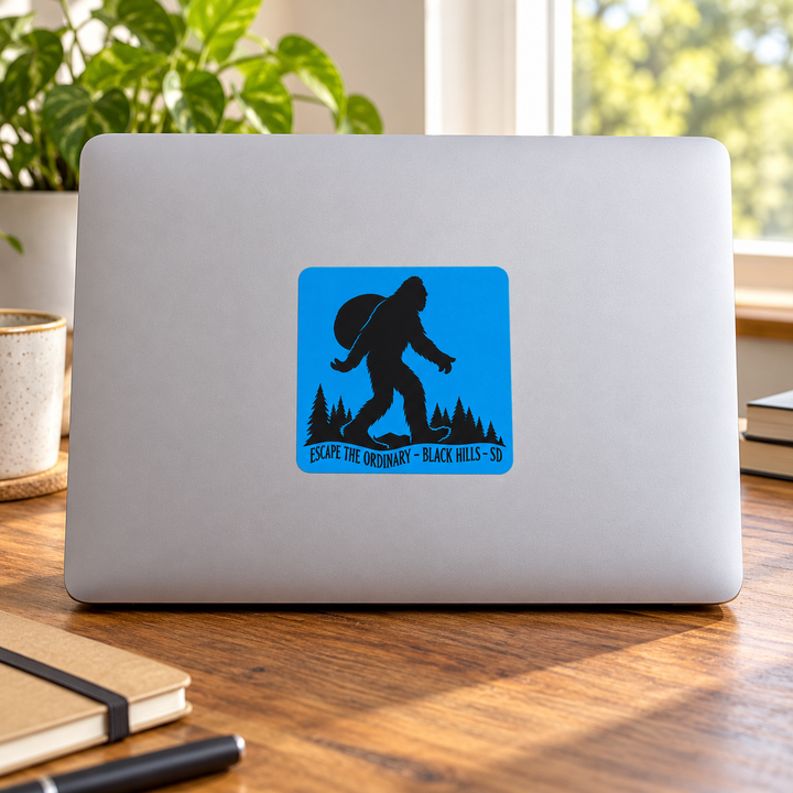 Black Hills Escape the Ordinary Bigfoot Backpacker Sticker on a laptop — lifestyle display mockup; accessories not included