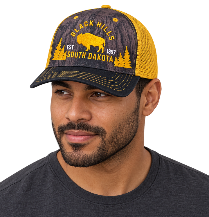 Man wearing Black Hills buffalo forest trucker hat in yellow and black