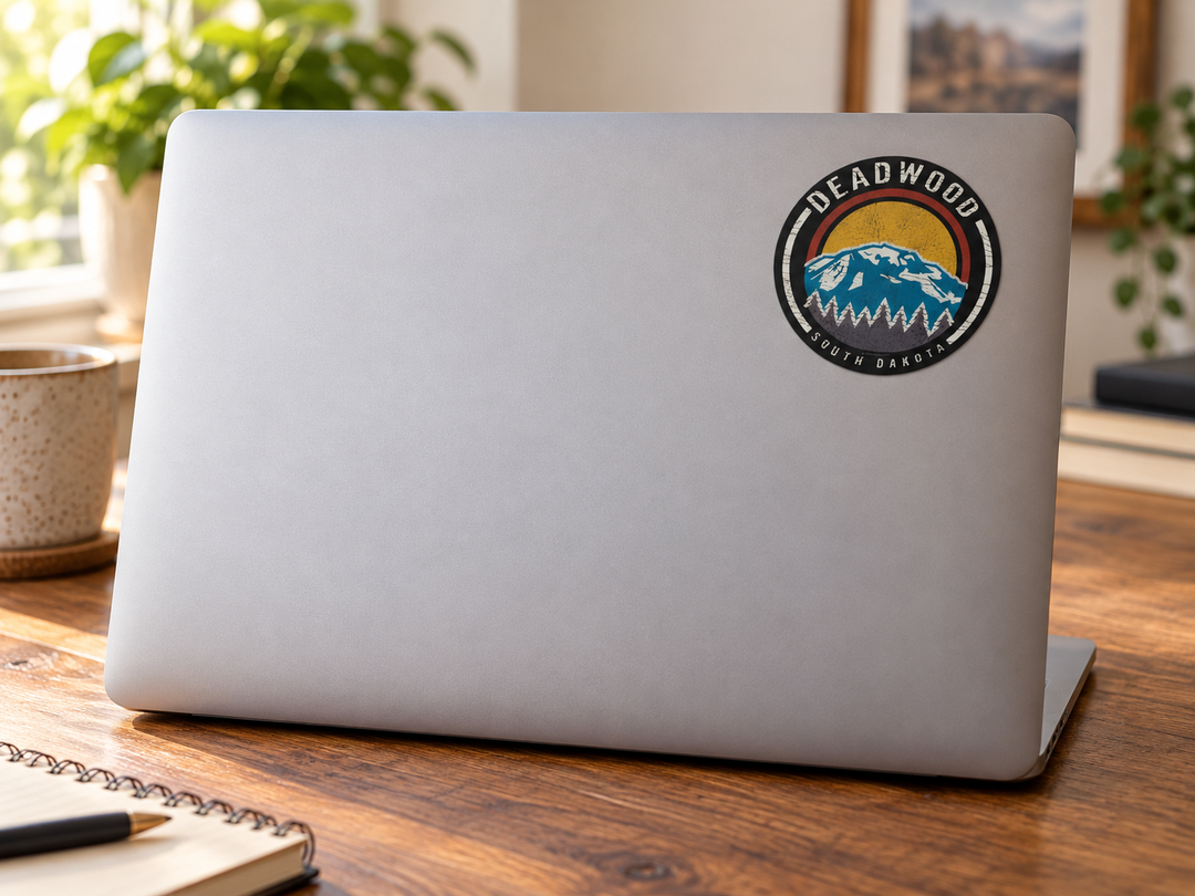 Deadwood Blue Mountain Sunset Round Sticker on a laptop cover at realistic scale