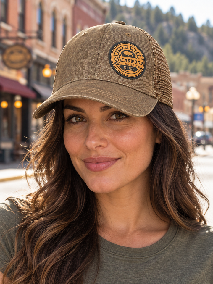 Deadwood Buffalo Heritage Leather Patch Trucker Hat – Washed Brown; female model wearing hat (AI-generated lifestyle image)