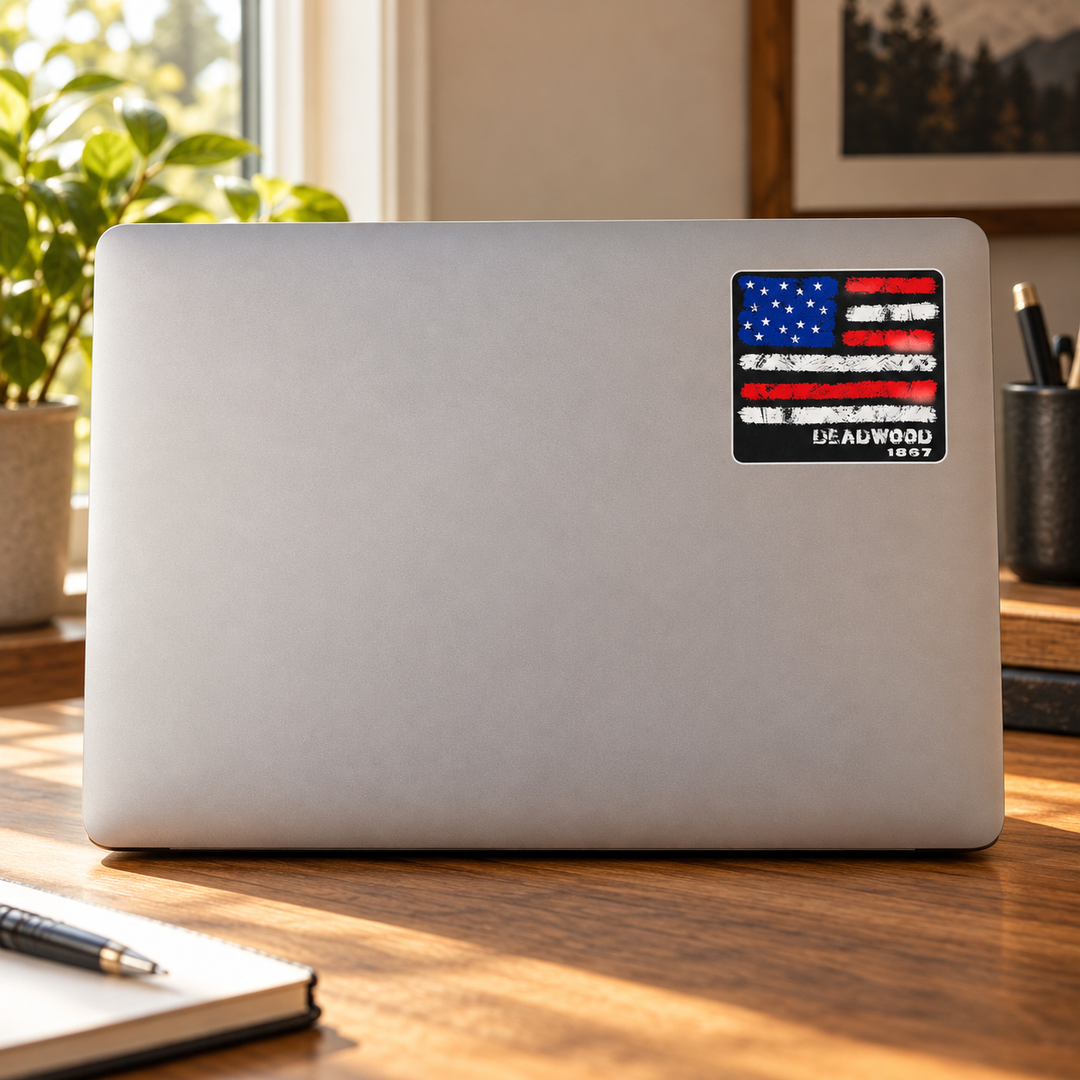 Deadwood Distressed American Flag Sticker on a laptop cover — realistic scale lifestyle display; accessories not included