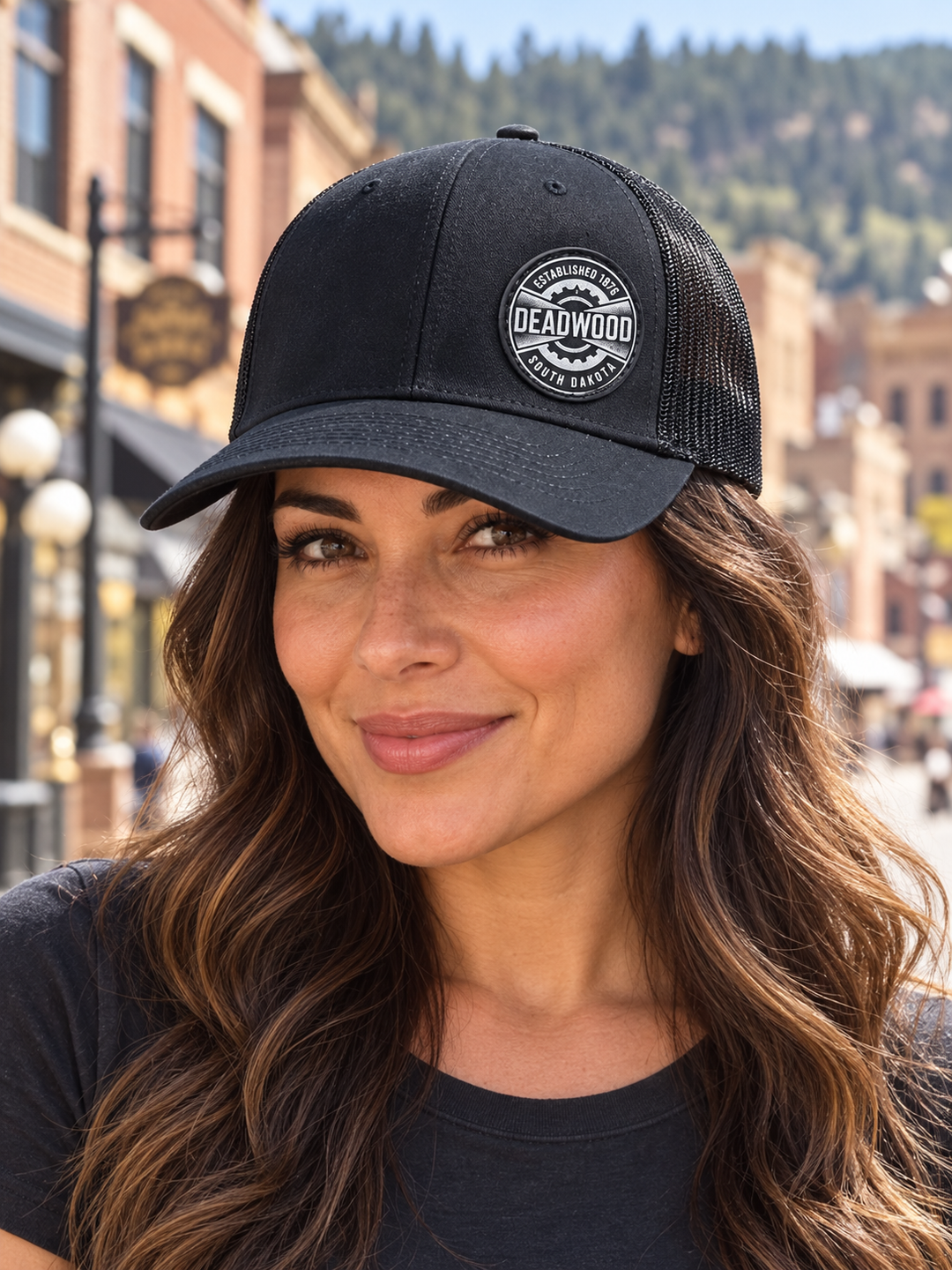Deadwood Heritage Badge Leather Patch Trucker Hat – Black; female model wearing hat (AI-generated lifestyle image)