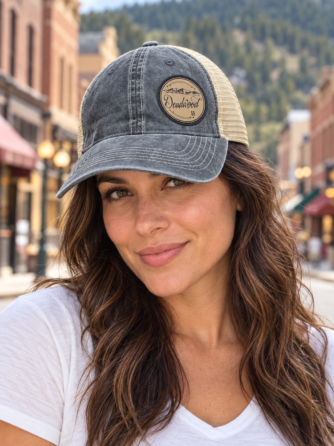 Deadwood Mountain Badge Leather Patch Trucker Hat – Washed Charcoal &amp; Tan; female model wearing hat (AI-generated lifestyle image)