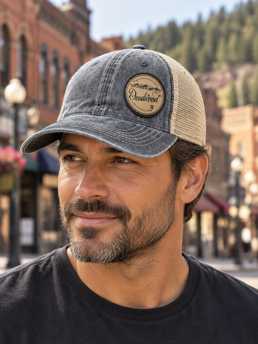 Deadwood Mountain Badge Leather Patch Trucker Hat – Washed Charcoal &amp; Tan; male model wearing hat (AI-generated lifestyle image)