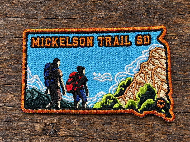 Mickelson Trail South Dakota Hiking Embroidered Patch — on weathered wood