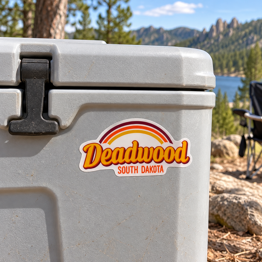 Deadwood Retro Rainbow Script Sticker on a cooler — lifestyle display mockup; accessories not included