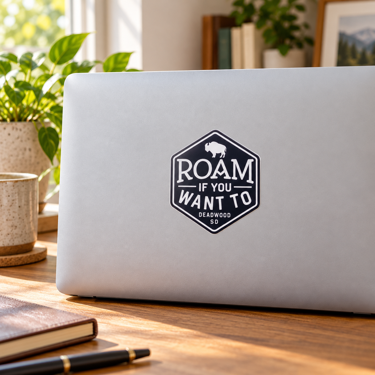 Deadwood Roam If You Want To Bison Sticker on a laptop — lifestyle display mockup; accessories not included