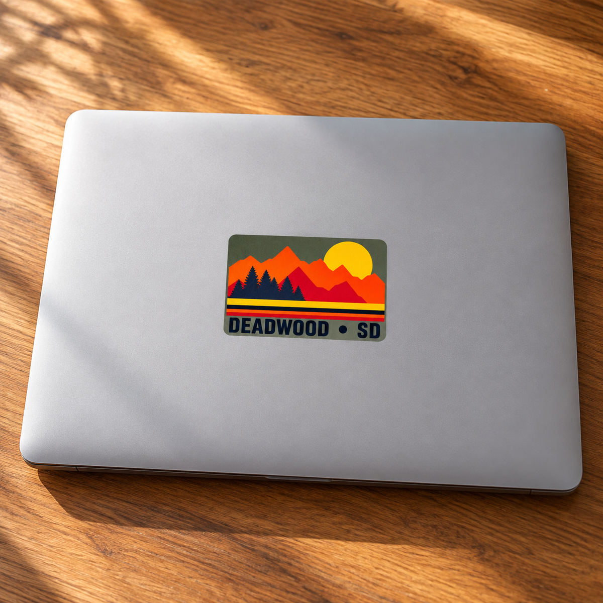 Deadwood Sunset Pines Rectangle Sticker on a laptop — lifestyle display mockup; accessories not included