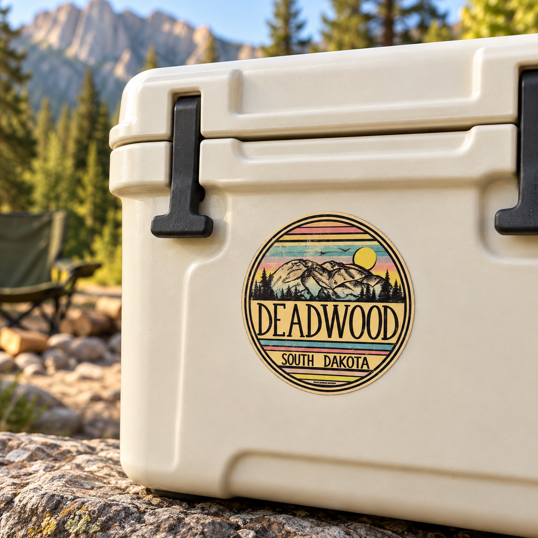 Deadwood Vintage Mountain Sunset Round Sticker on a cooler — lifestyle display mockup; accessories not included