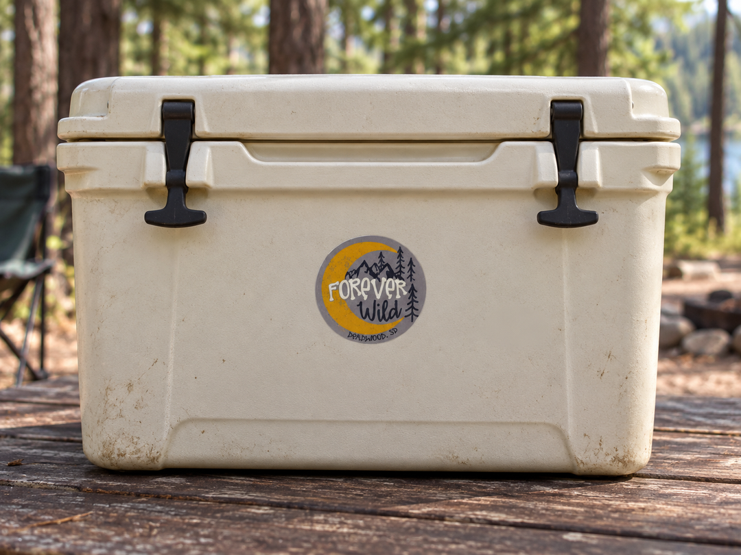 Forever Wild Mountain &amp; Pines Round Sticker – Grey &amp; Yellow on a camping cooler at realistic scale
