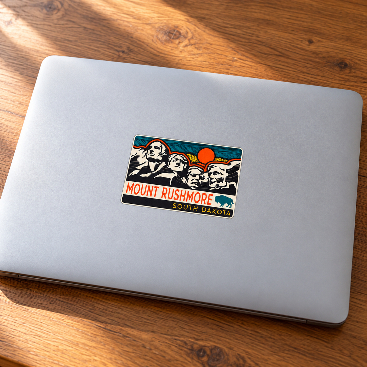 Mount Rushmore Presidents & Bison Sunset Sticker on a laptop — lifestyle display mockup; accessories not included